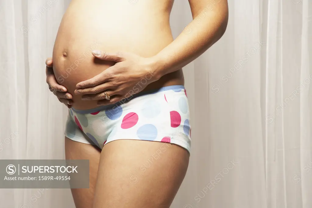 Pregnant Mixed Race woman with hands on belly