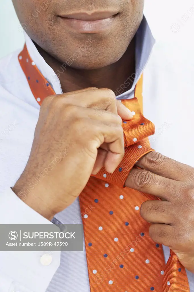 African American man tying necktie