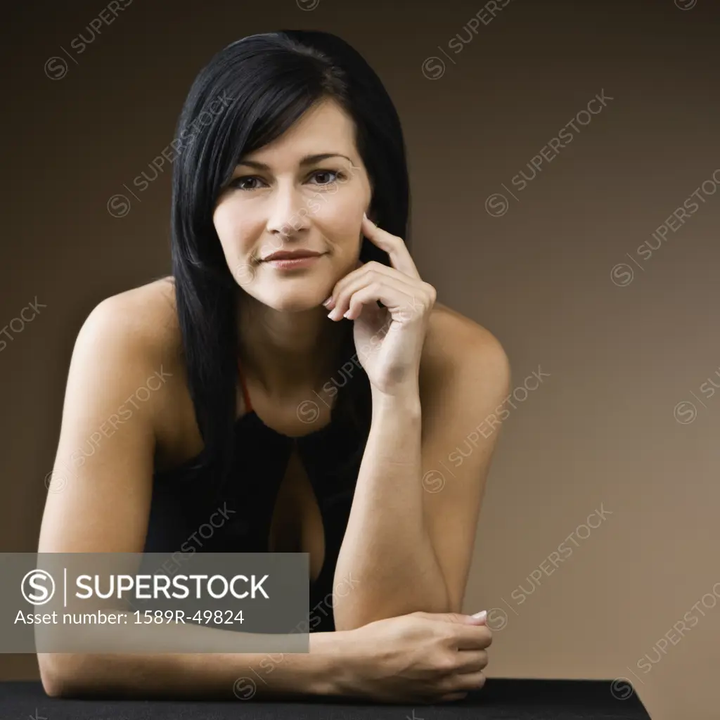 Hispanic woman resting elbow on table