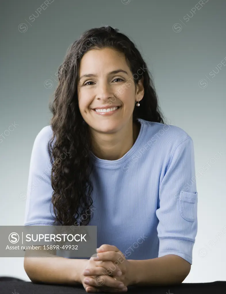 Hispanic woman with hands clasped