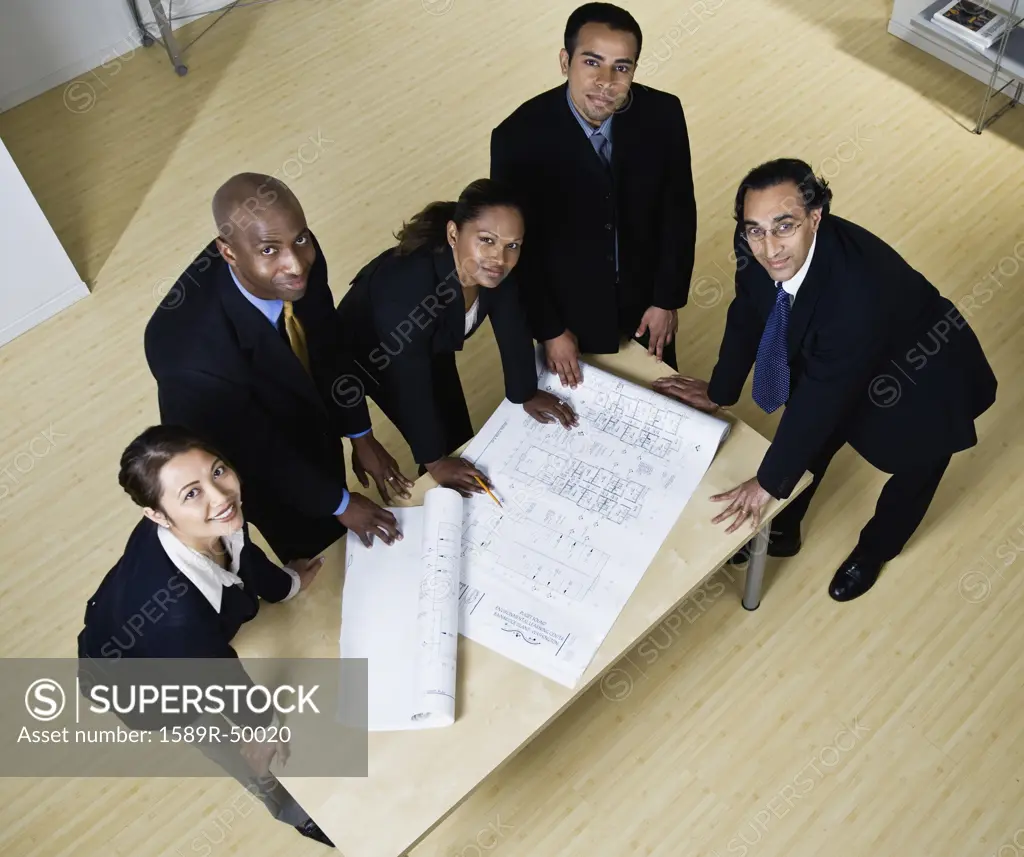 Multi-ethnic businesspeople with blueprints
