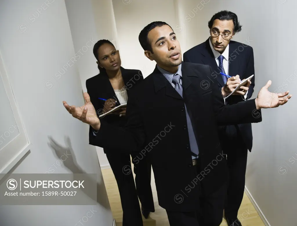 Multi-ethnic businesspeople walking in hallway