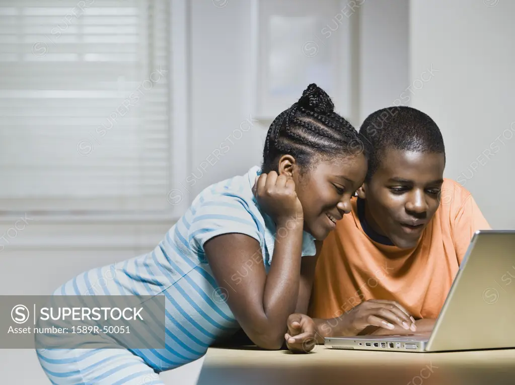 African siblings looking at laptop