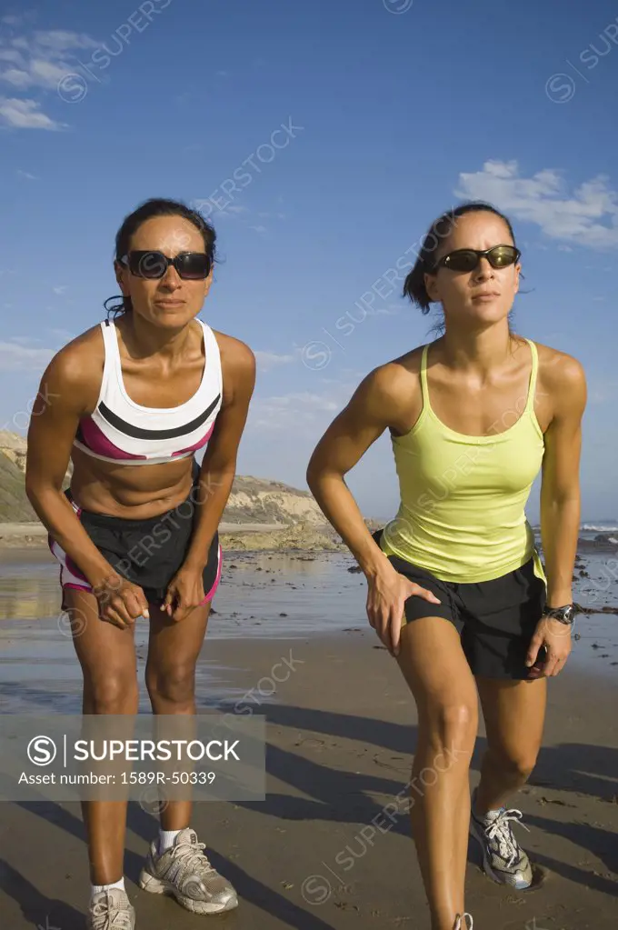 Hispanic female runners racing at beach