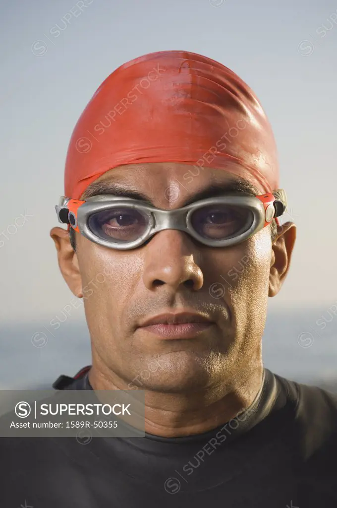 Hispanic man wearing wetsuit and goggles