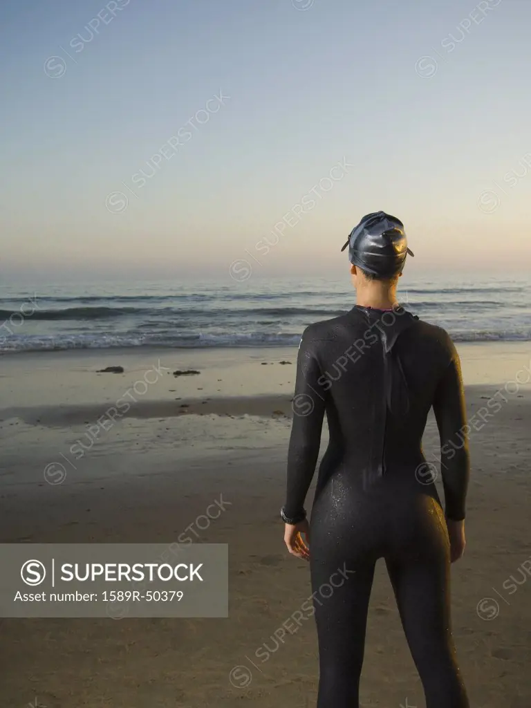 Rear view of Hispanic woman wearing wetsuit