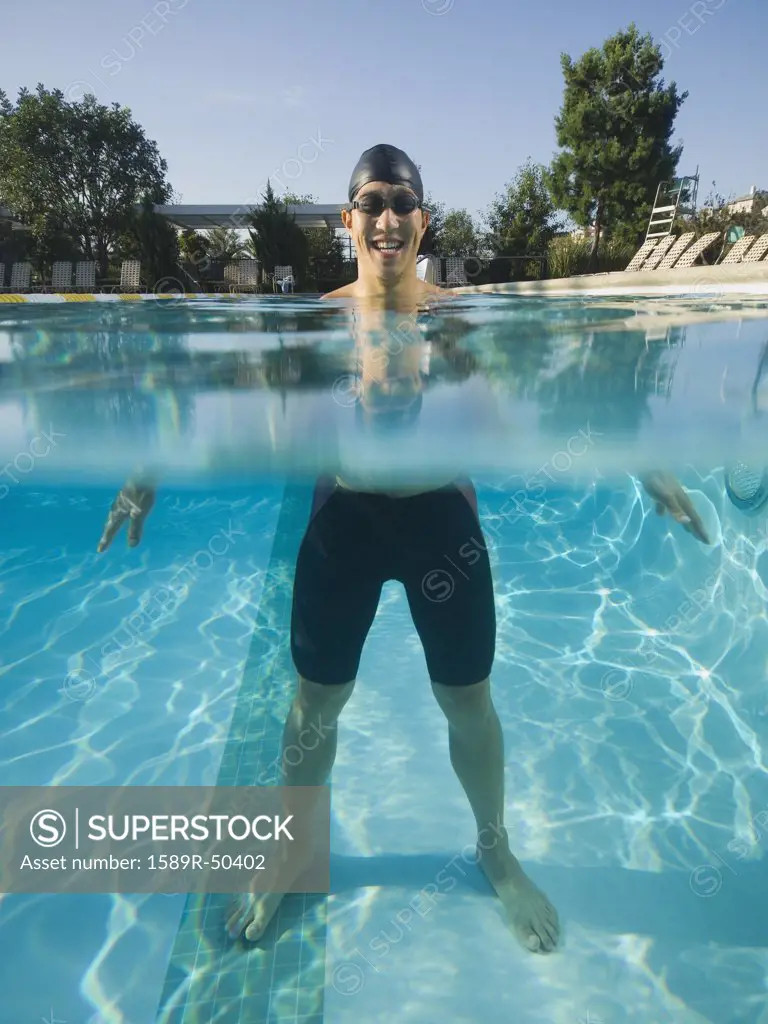 Asian man standing in swimming pool
