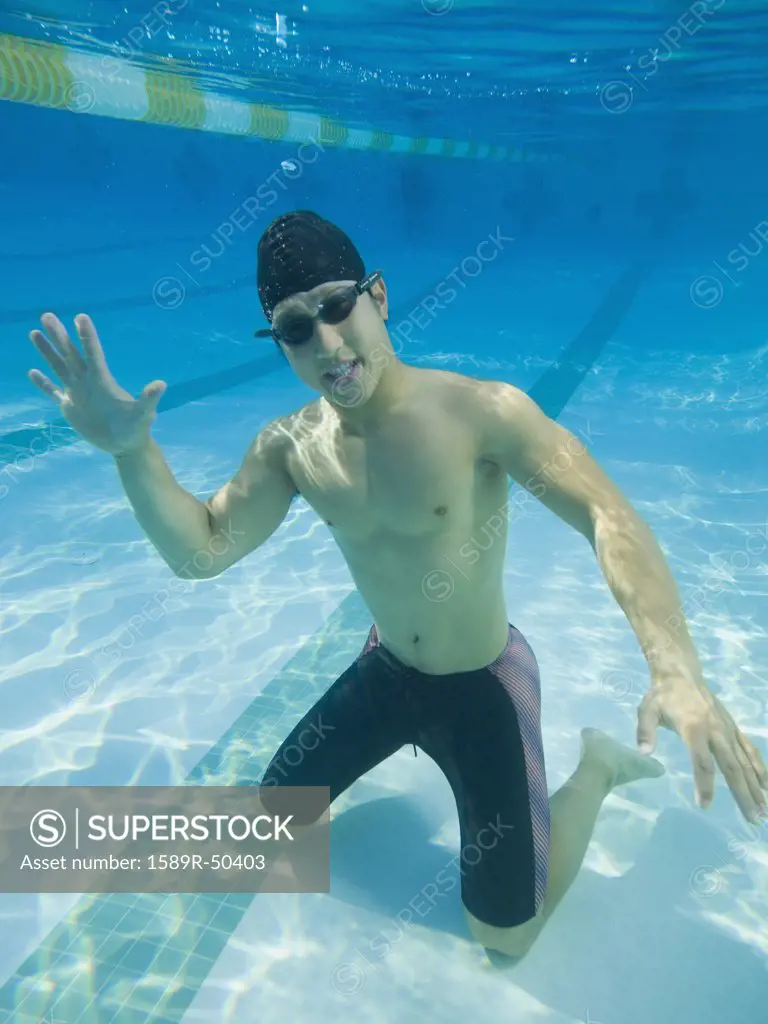 Underwater shot of Asian man waving