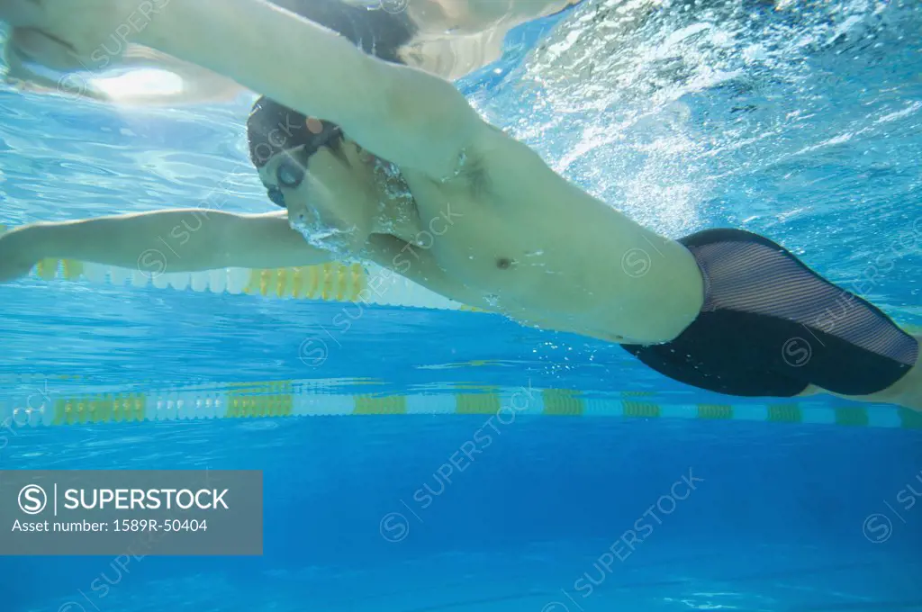 Underwater shot of Asian man swimming