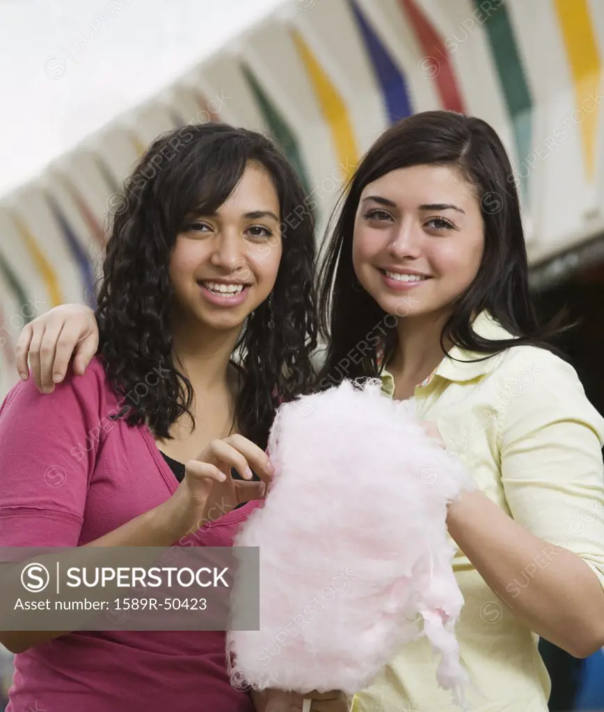 Multi-ethnic teenaged girls eating cotton candy