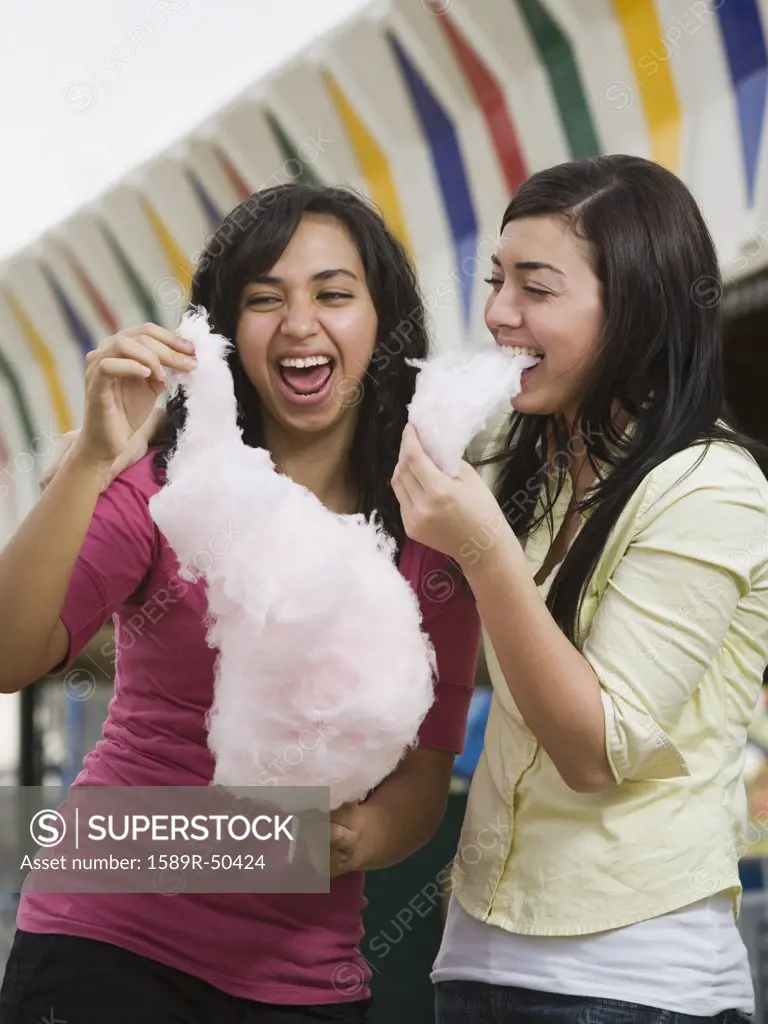 Multi-ethnic teenaged girls eating cotton candy