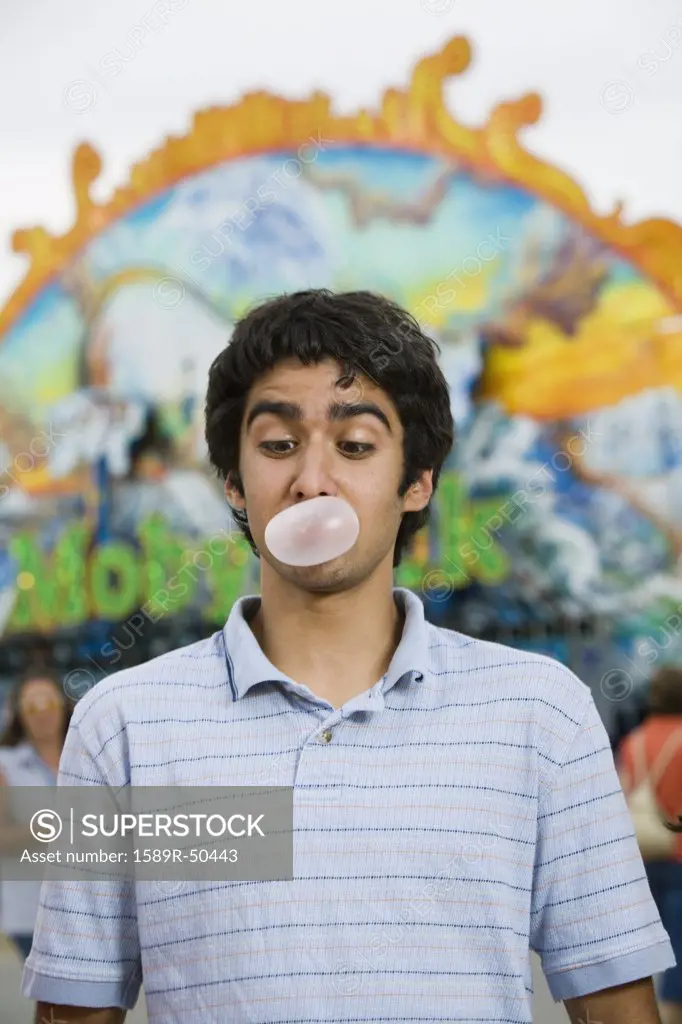 Mixed Race teenaged boy blowing bubble gum bubble