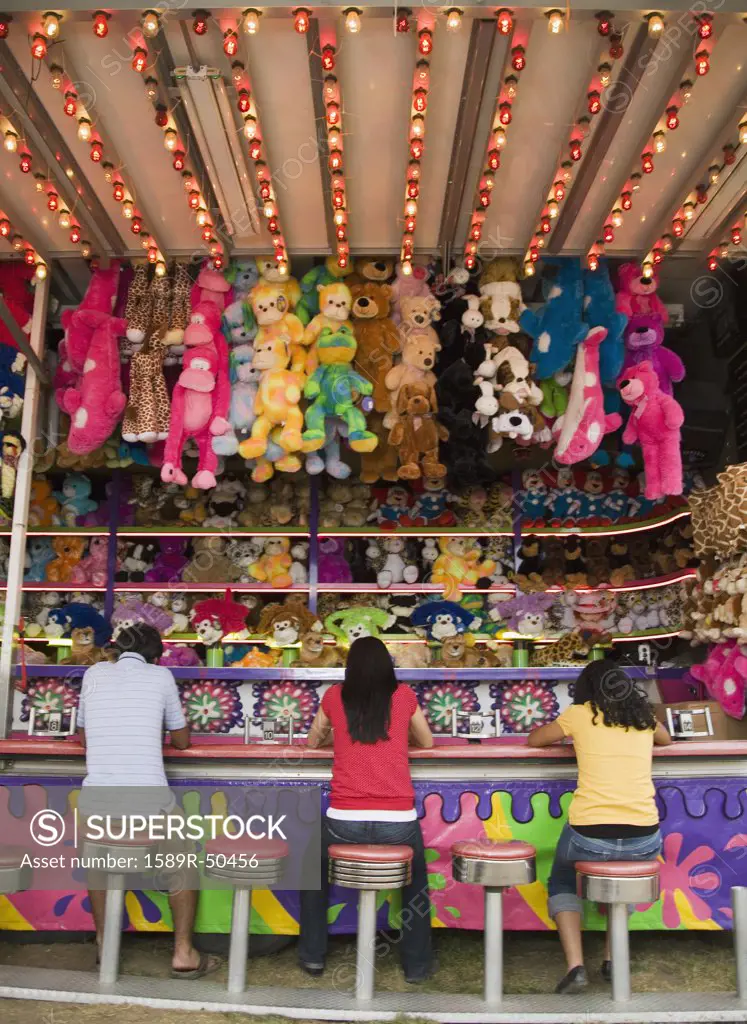 Multi-ethnic teenaged friends playing carnival game