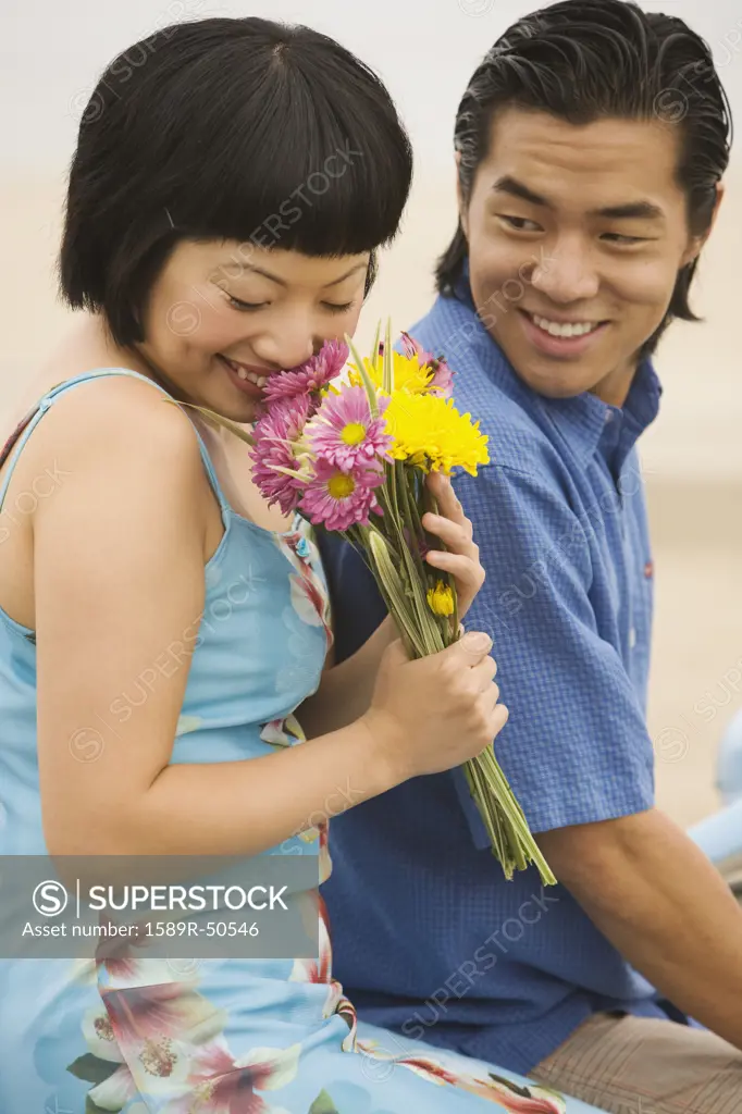 Asian couple with bouquet of flowers
