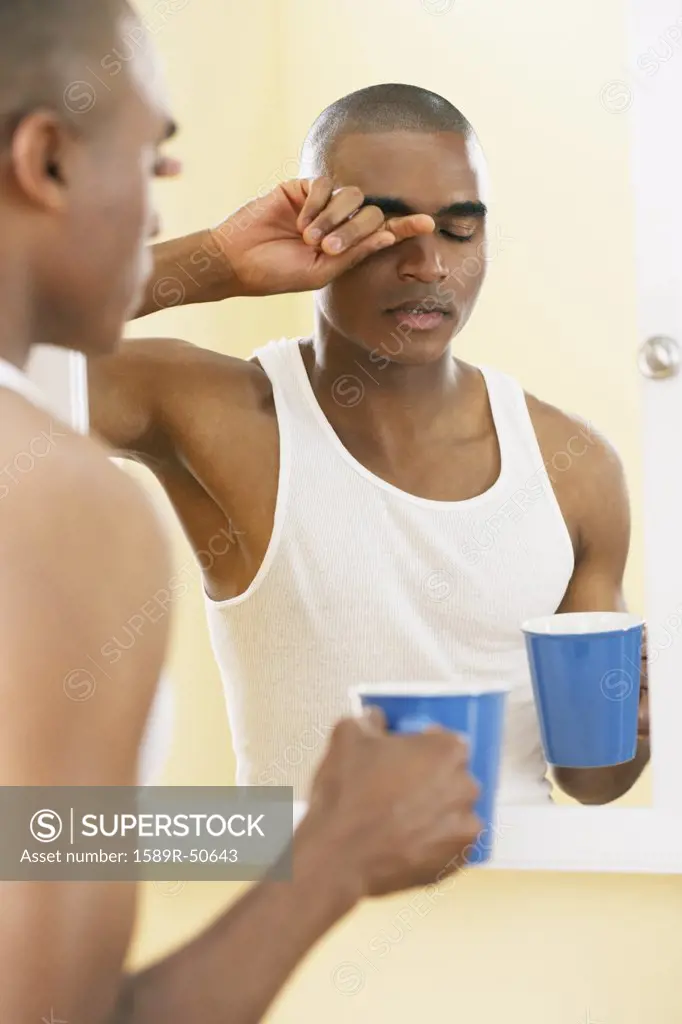 African man rubbing eyes