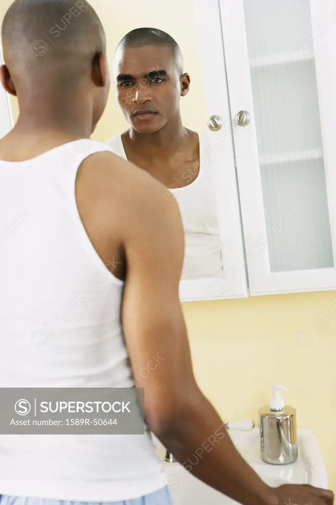 African man looking in mirror