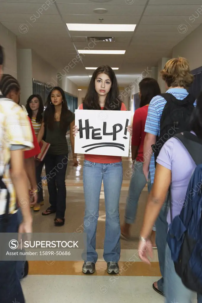 Female teenaged student holding Help sign