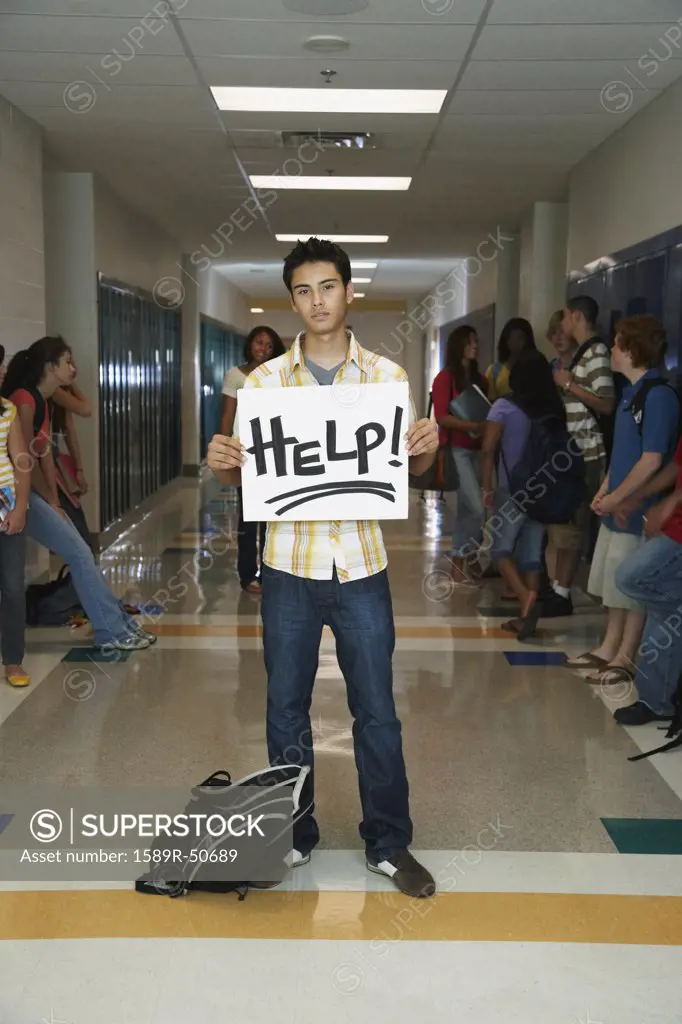 Hispanic teenaged student holding Help sign