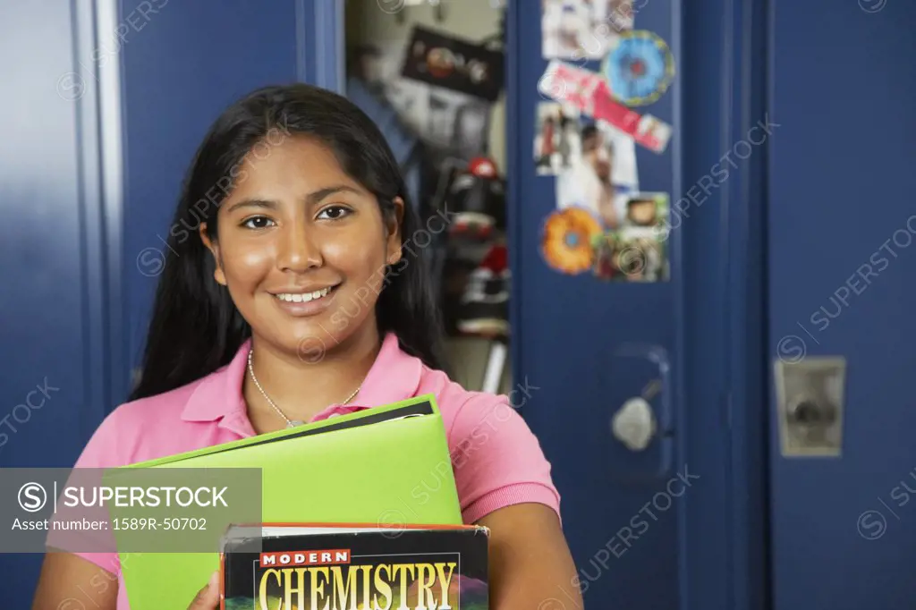 Hispanic teenaged girl in front of school locker
