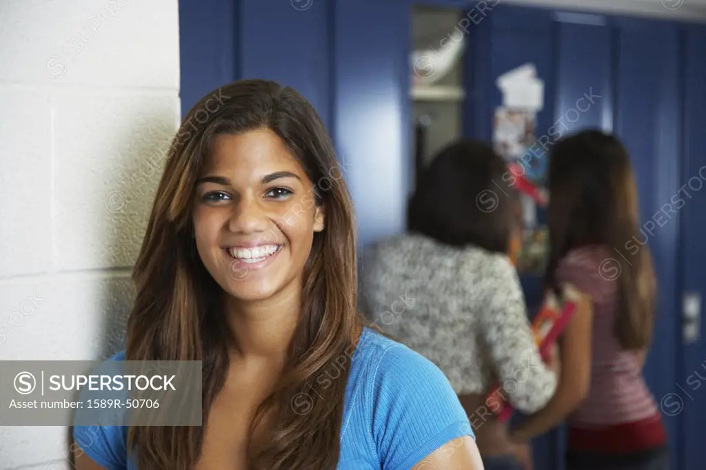 Mixed Race teenaged girl in front of school lockers