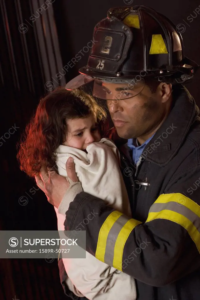 Hispanic male firefighter holding child