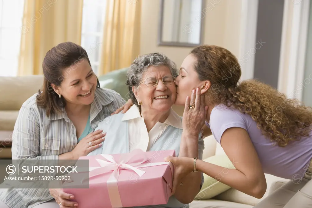 Hispanic woman giving gift to grandmother