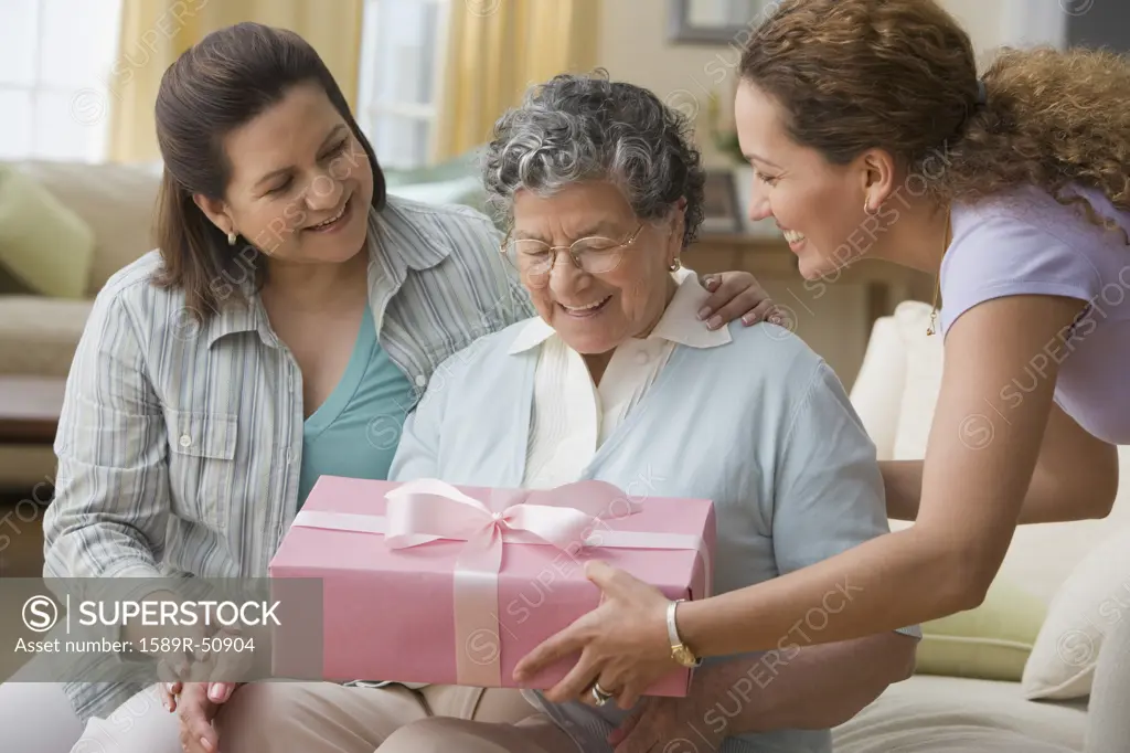Hispanic woman giving gift to grandmother