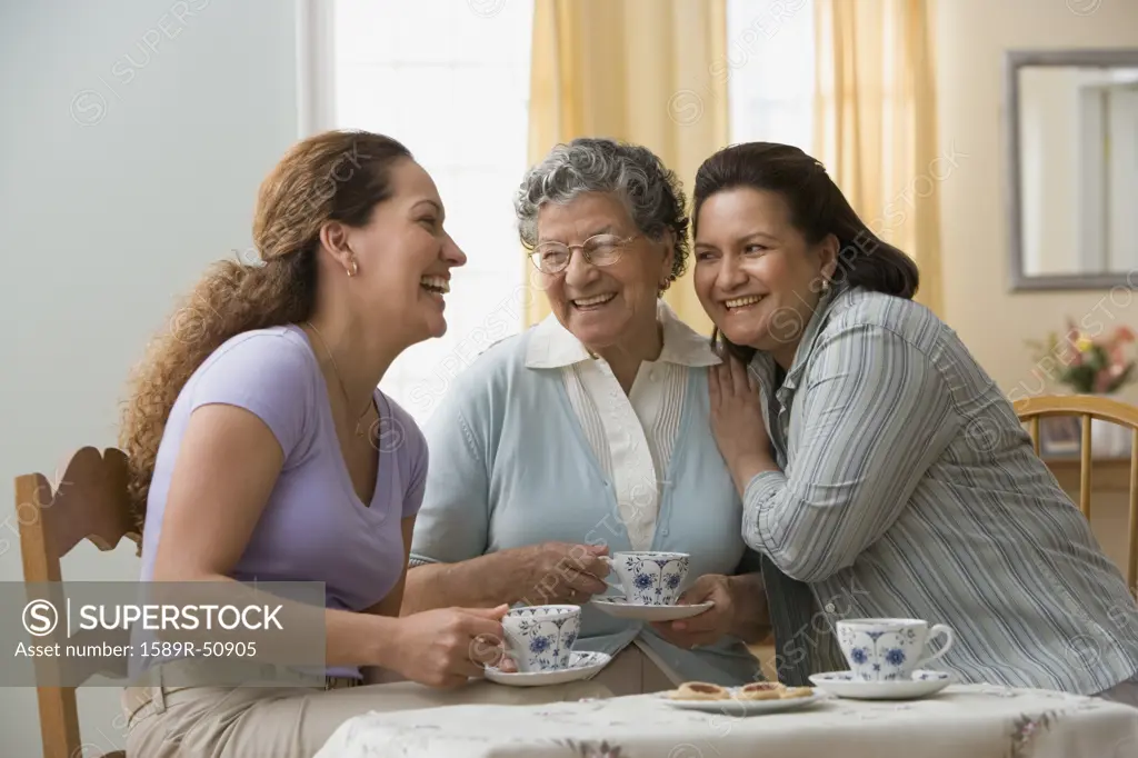 Hispanic grandmother, mother and daughter having tea