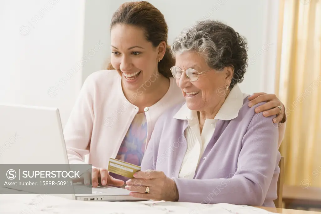 Hispanic woman and adult granddaughter shopping online