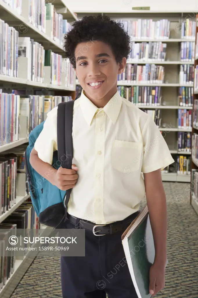 Hispanic boy holding backpack