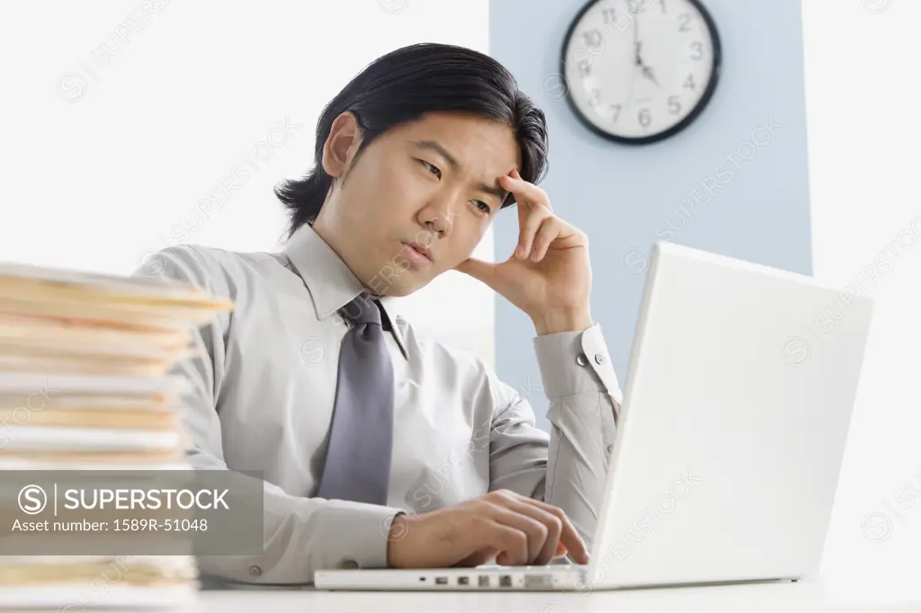 Asian businessman looking at laptop