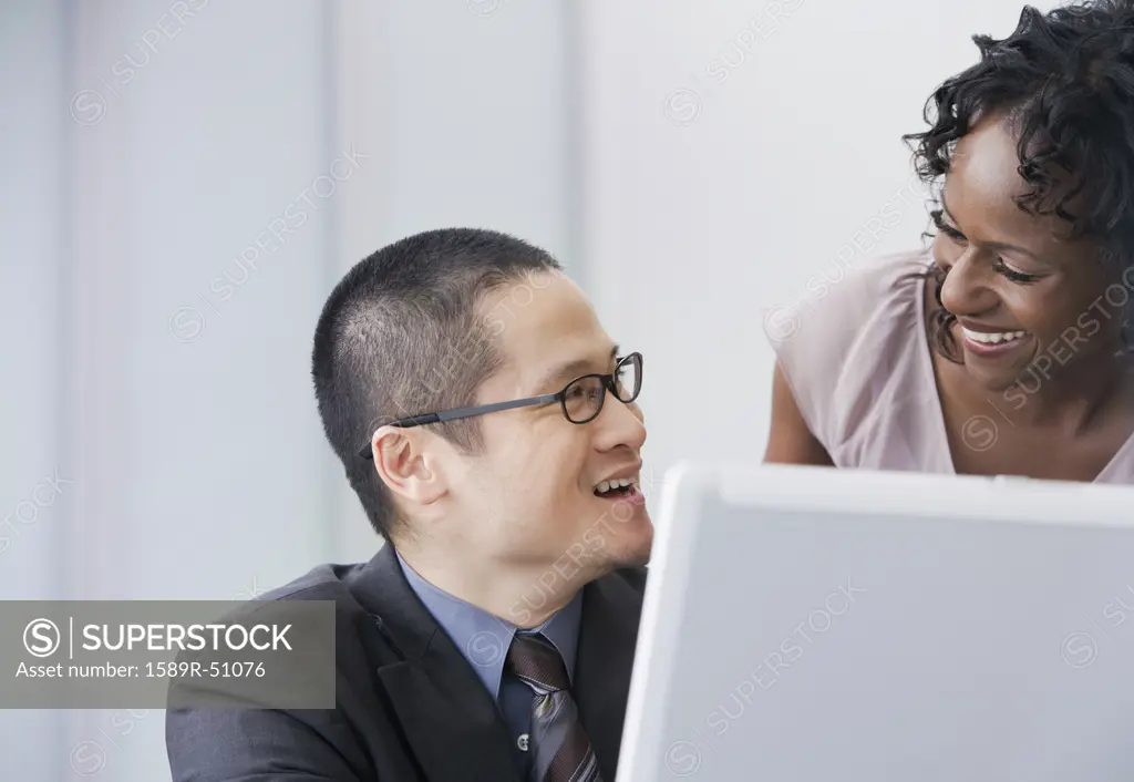 Multi-ethnic businesspeople smiling at each other