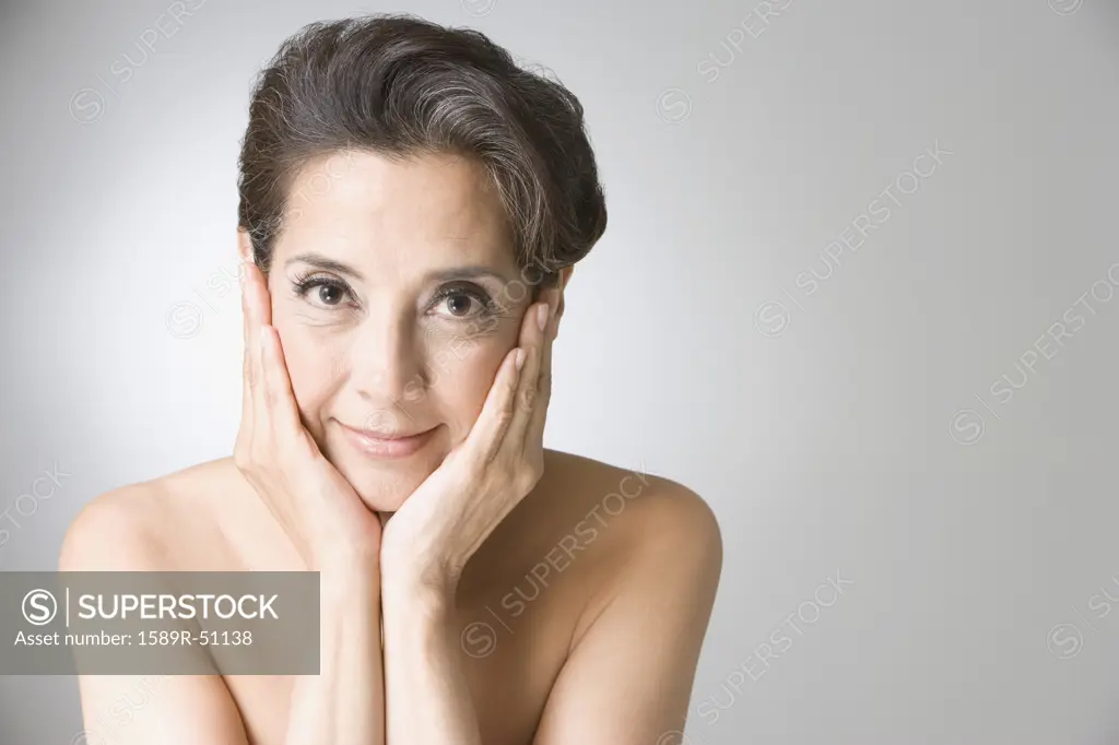Hispanic woman with hands on face