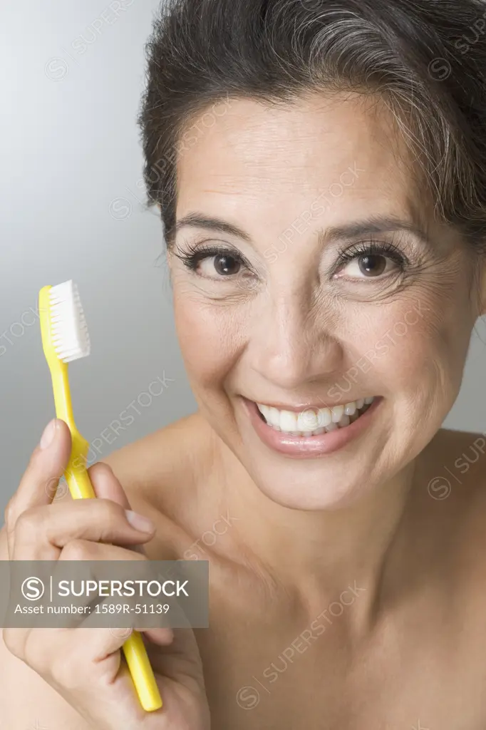 Hispanic woman holding toothbrush