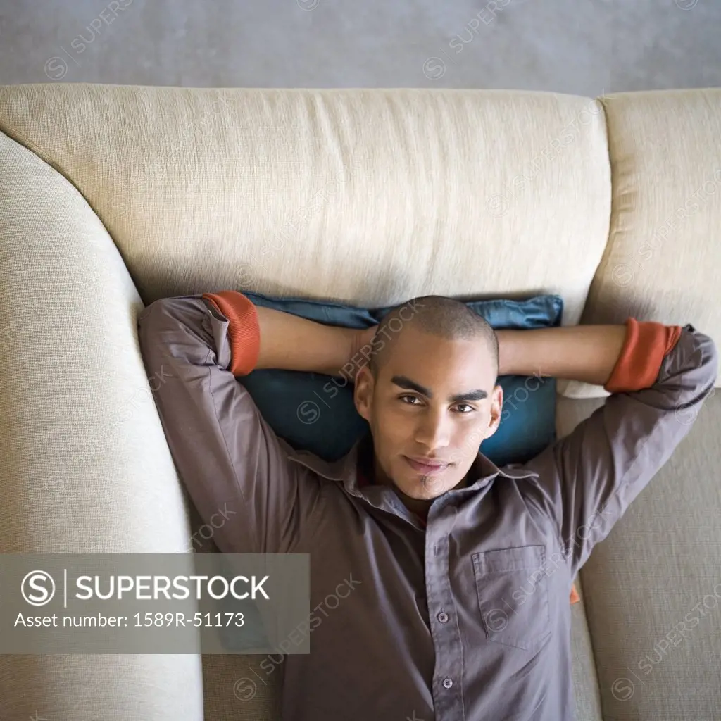 African American man laying on sofa