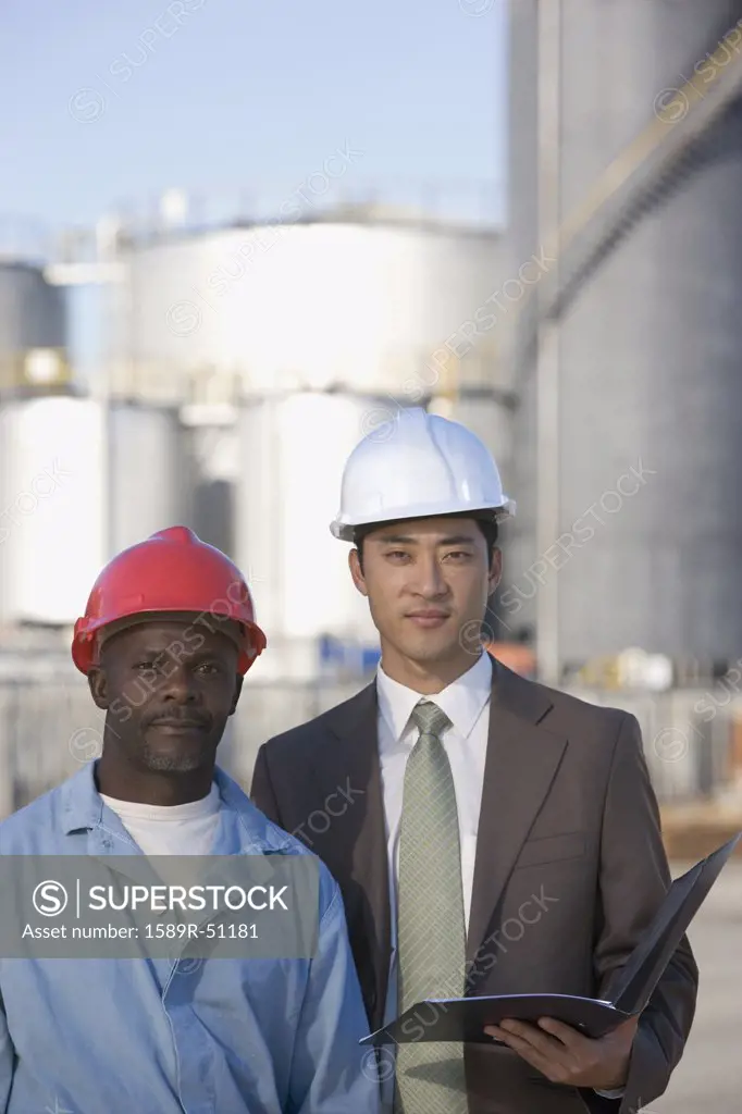 Multi-ethnic businessman and construction worker wearing hardhats