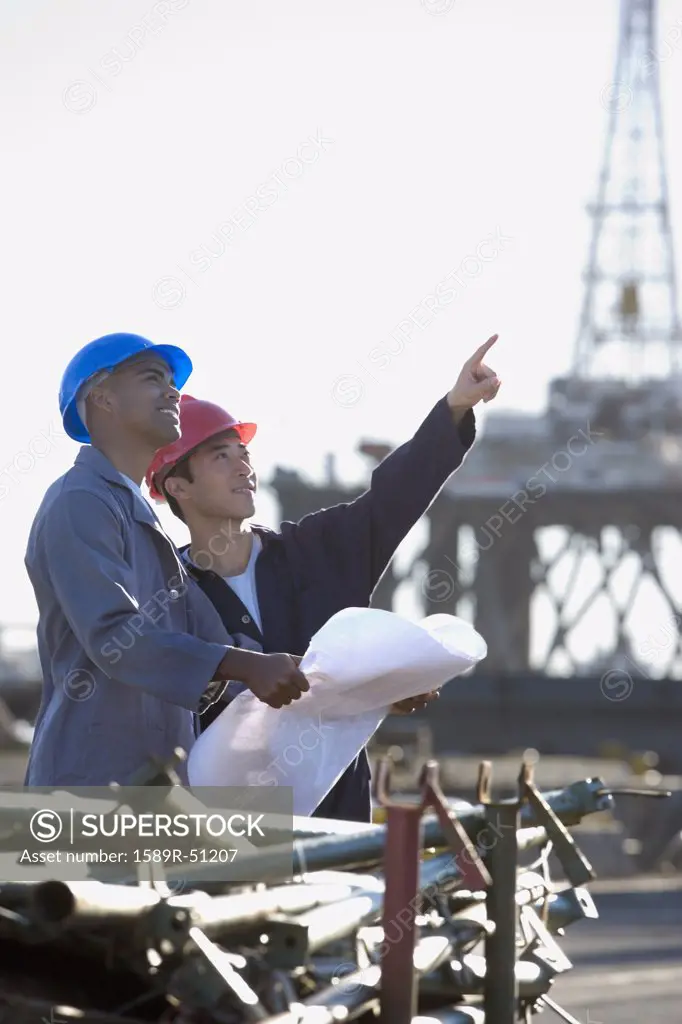 Multi-ethnic male construction workers pointing