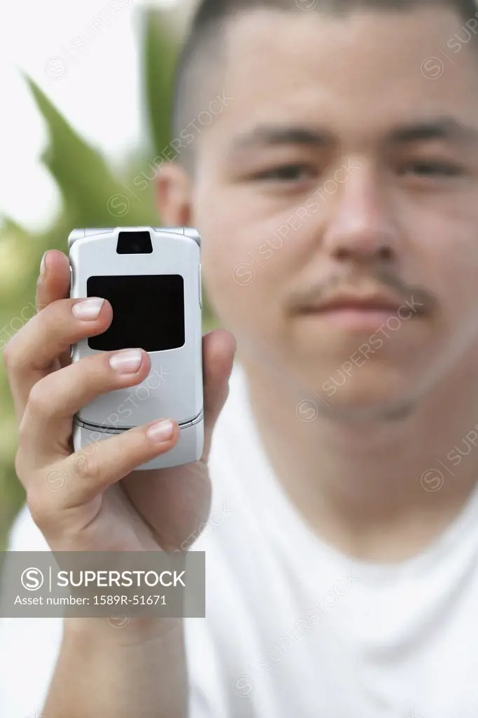 Pacific Islander man holding cell phone