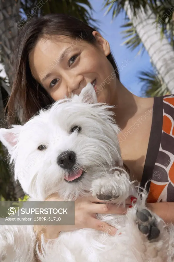 Asian woman holding dog