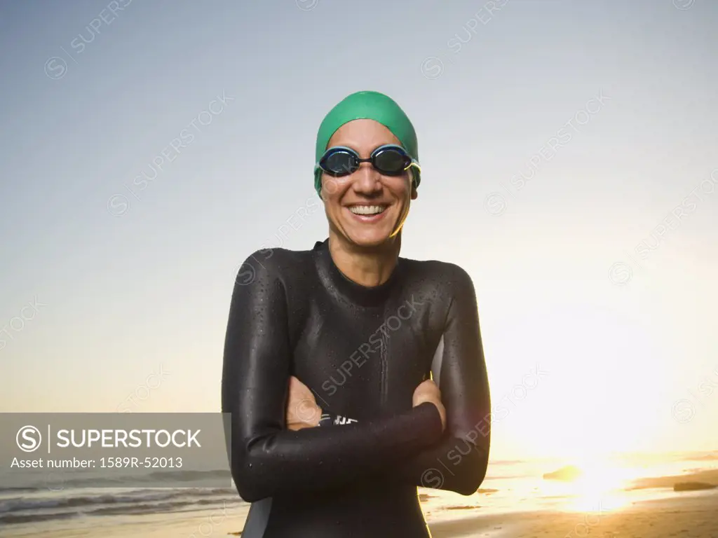 Hispanic woman wearing wetsuit and goggles