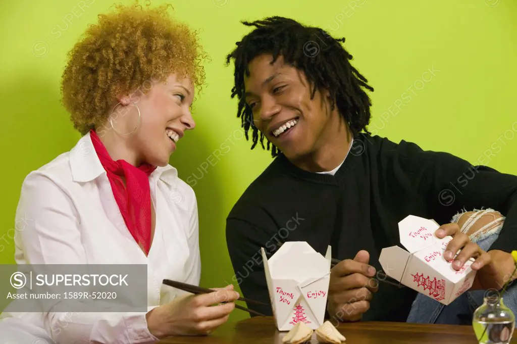 African couple eating takeout food