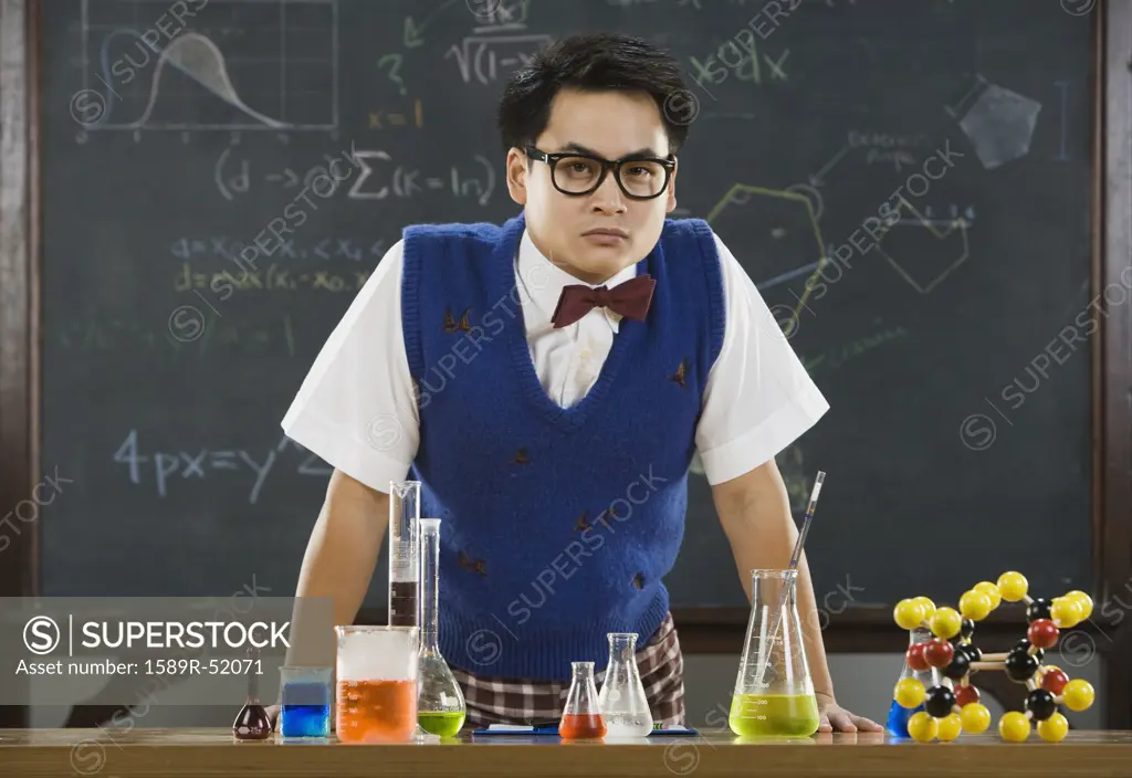 Nerdy Asian male student in science class