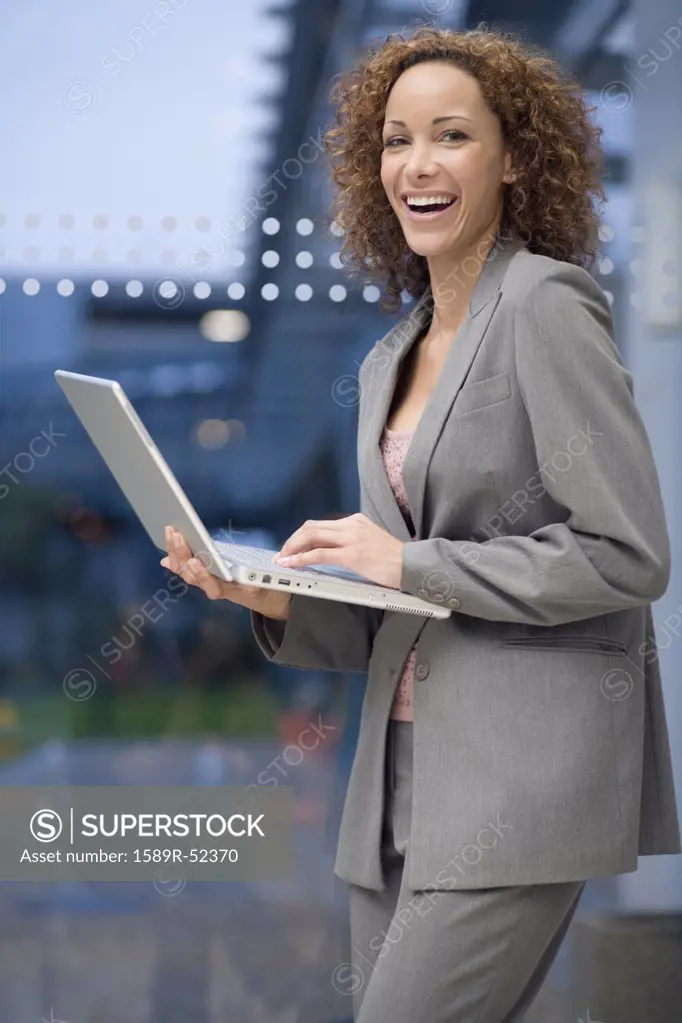 African businesswoman holding laptop