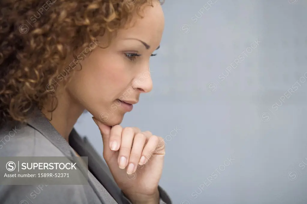 African businesswoman resting chin on hand