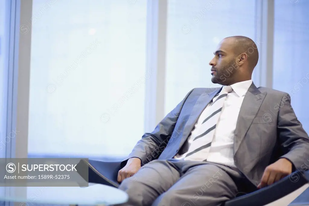 African businessman looking out window