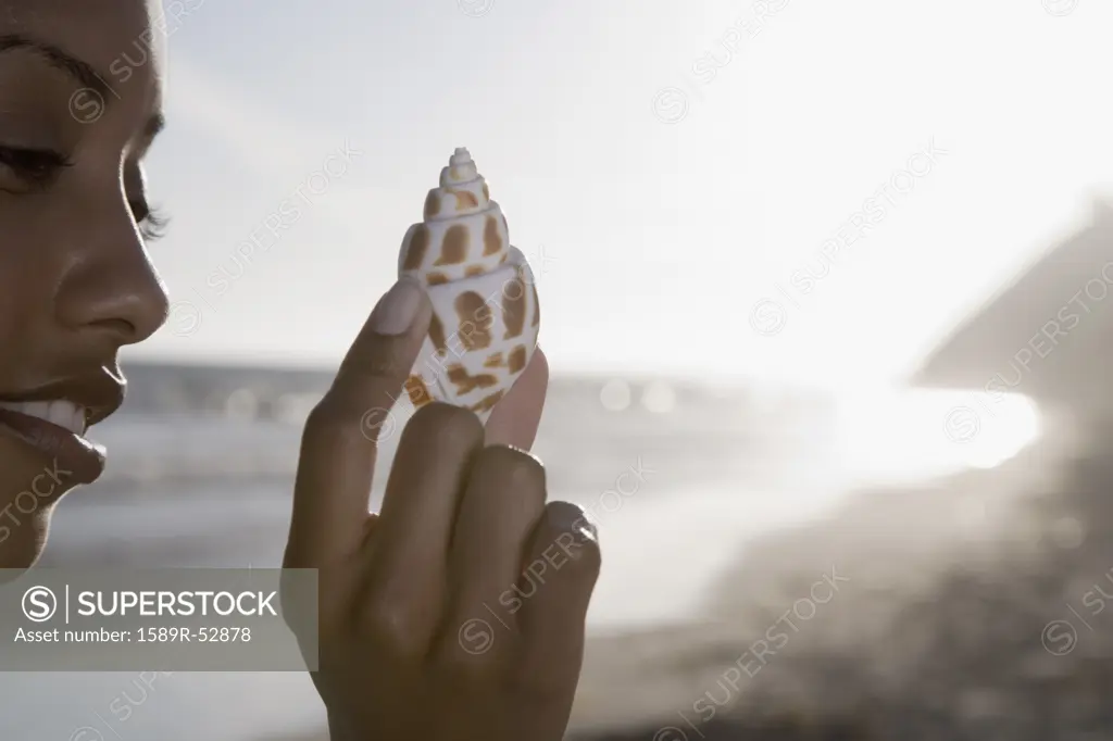 African woman holding seashell