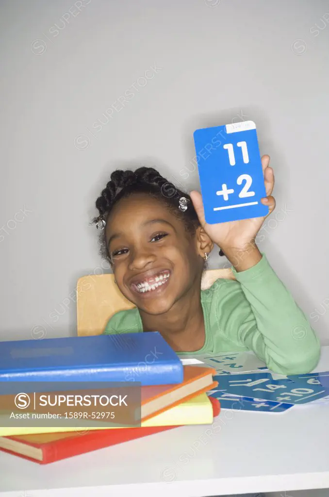 African girl holding addition flash cards