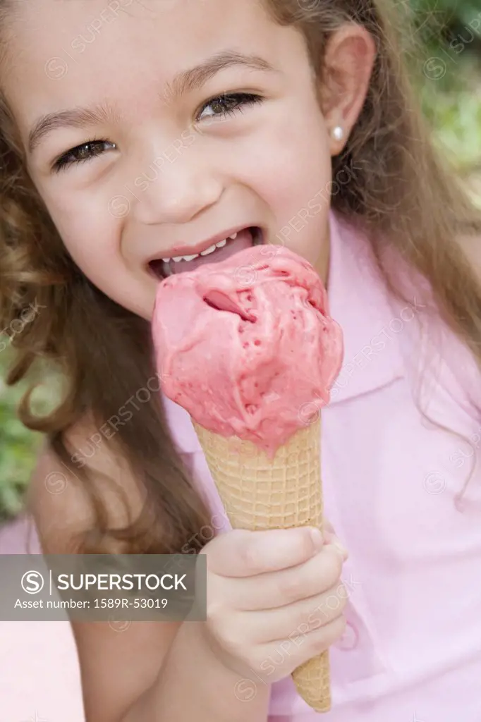 Hispanic girl eating ice cream cone