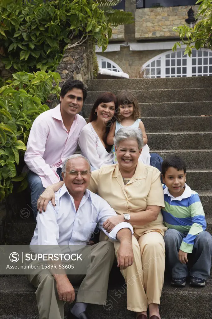 Multi-generational Hispanic family sitting on steps