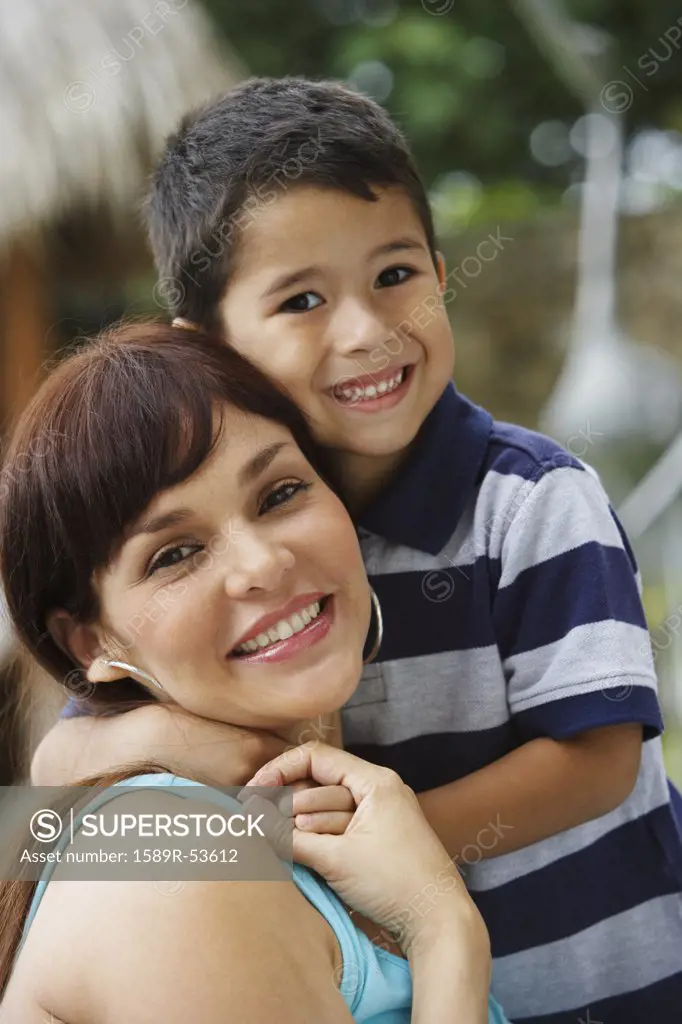 Hispanic mother and son hugging